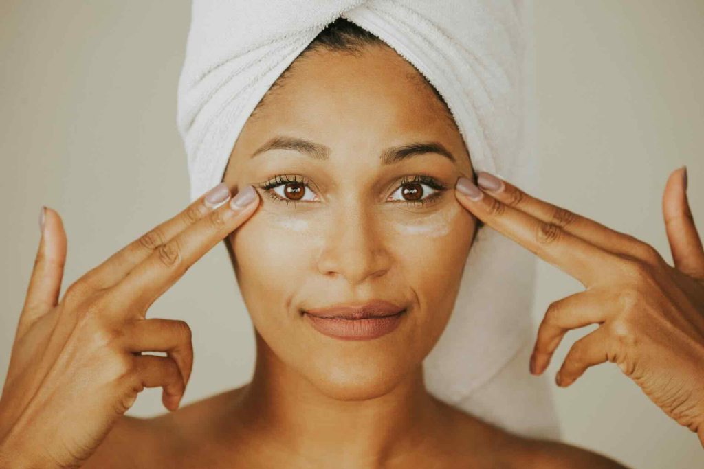 Woman applying cream to her face