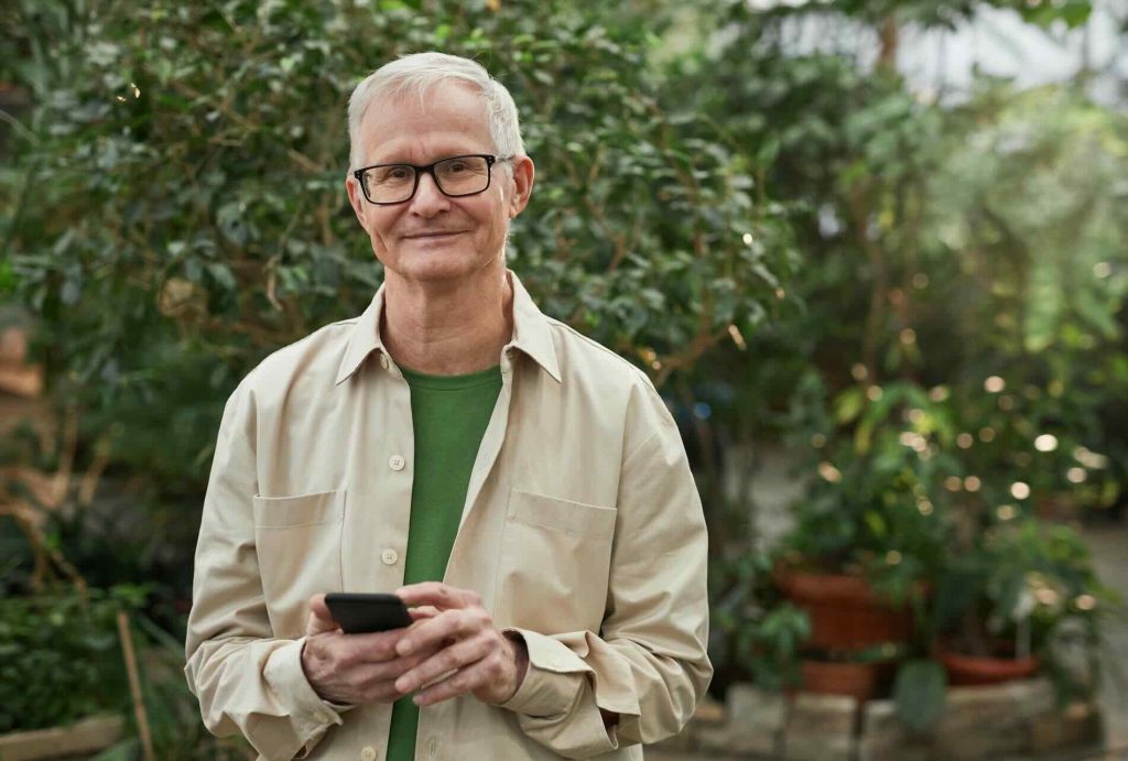 Happy older man holding a phone and smiling