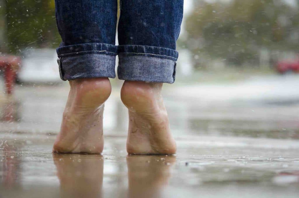 Man standing barefoot in the rain