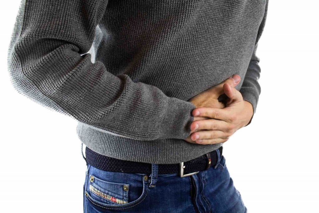 Man with an upset stomach, hands on his stomach area