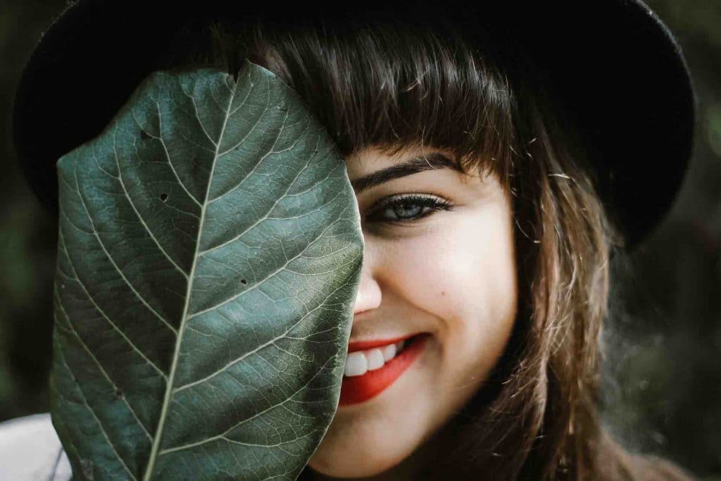 Woman with a beautiful, bright smile and a leaf