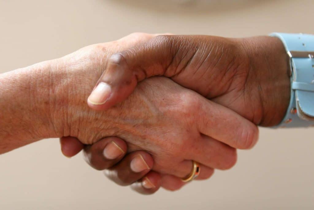 Nurse and elder shaking hands