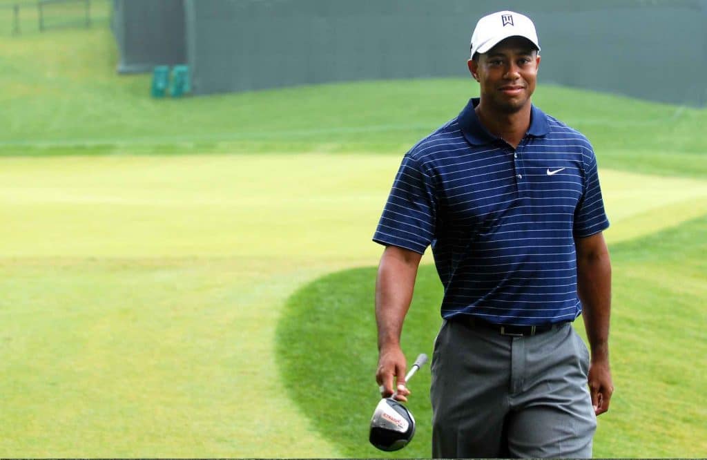 A healthy Tiger Woods walking across a golfing green