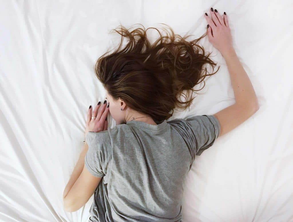 Woman sleeping face-down on a bed