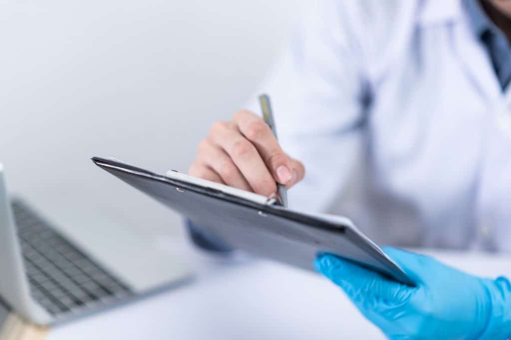 A doctor working at a concierge health clinic, writing notes on a tablet