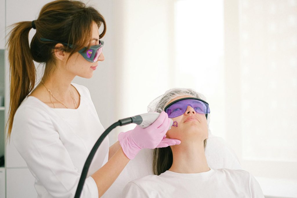 Woman administering Pico Laser treatment on a patient