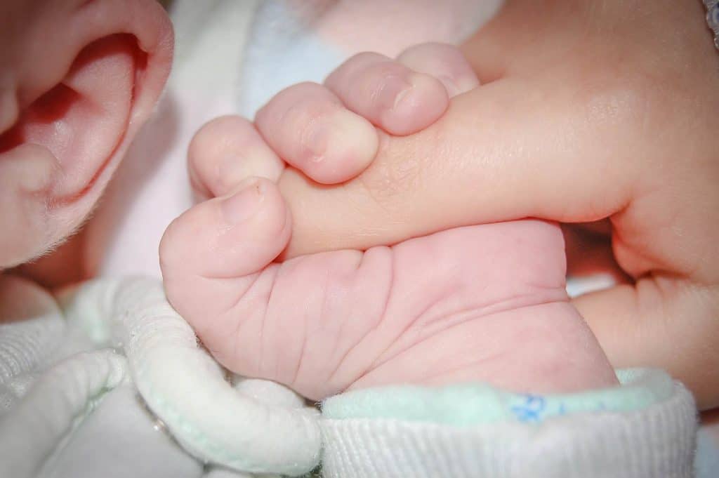 Baby holding a mother's finger