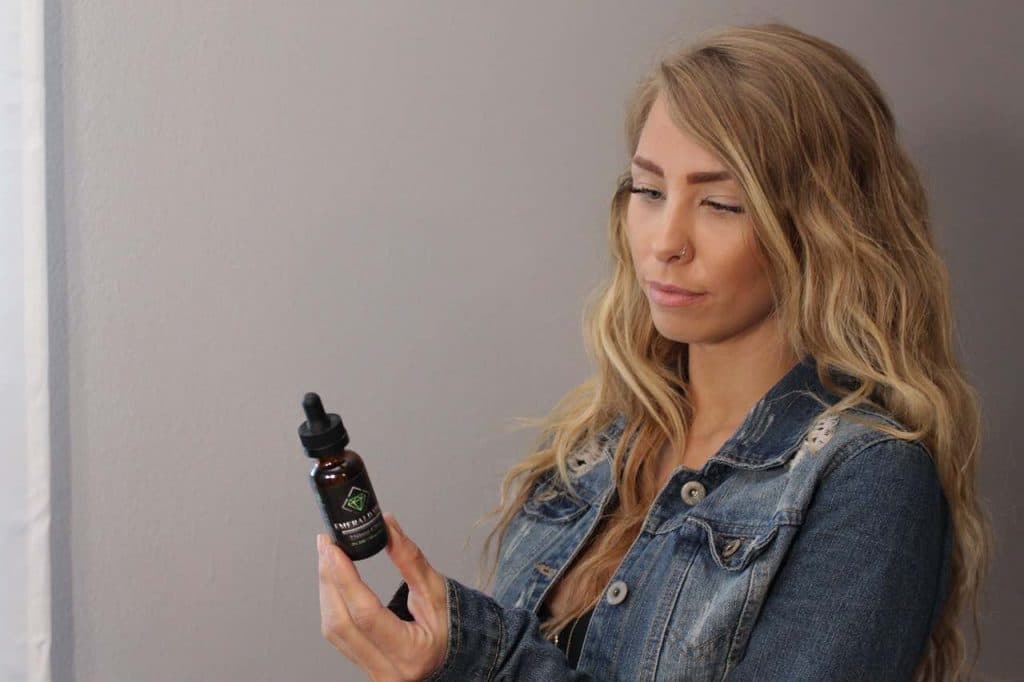 Woman looking at a bottle of CBD oil