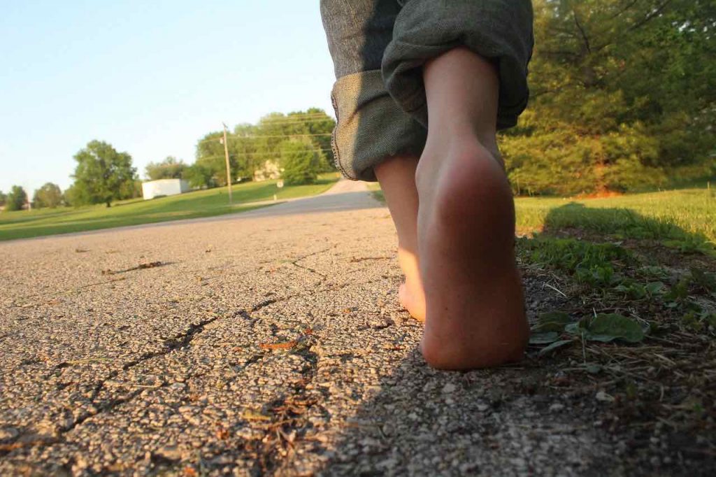 Young boy's feet walking barefoot on concrete