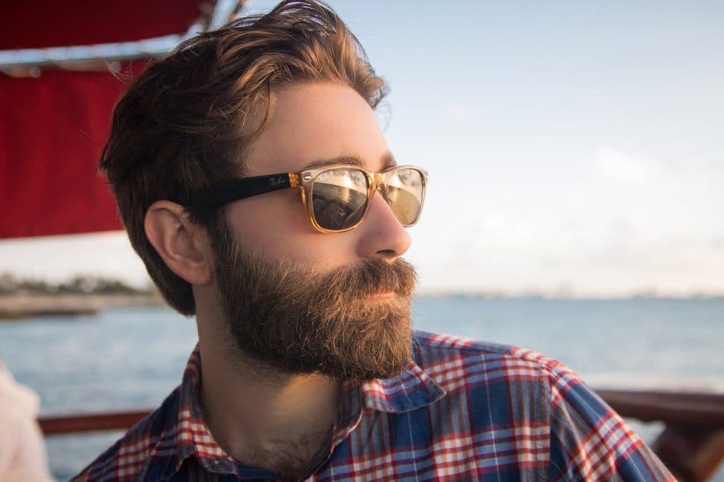 Man with a healthy beard on a boat during sunset