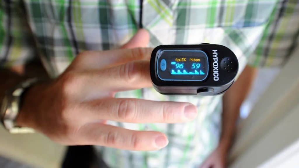 Man wearing a personal pulse oximeter on his finger