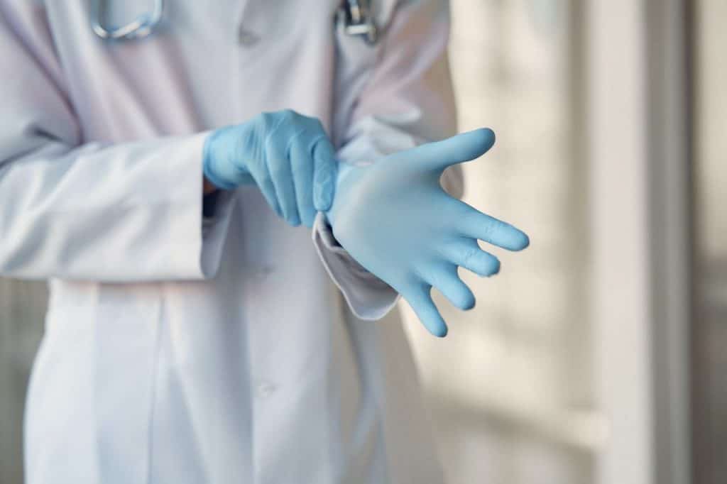 Medical technician putting on sterile gloves