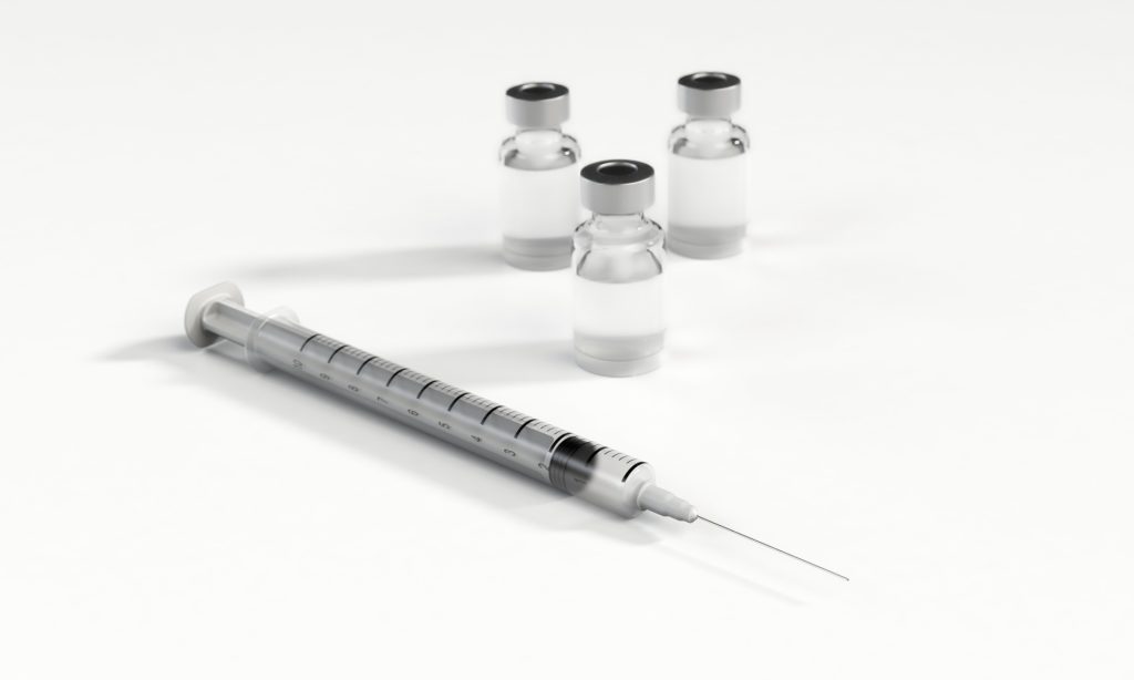 Syringe and bottles on a white background