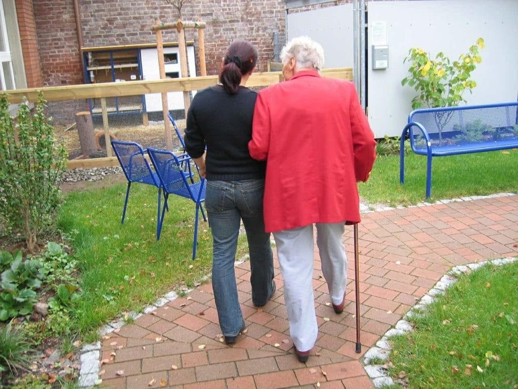 Home nurse going for a walk with elder