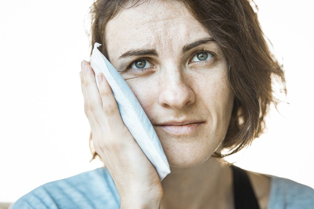 Woman holding a cold compress to her cheek