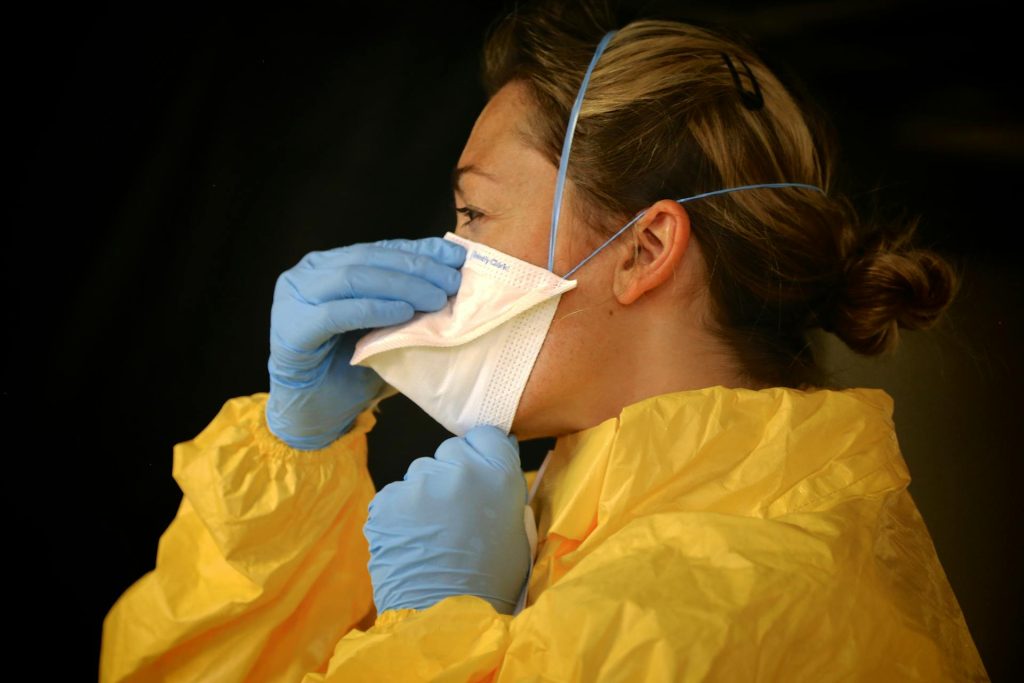 Nurse putting on PPE