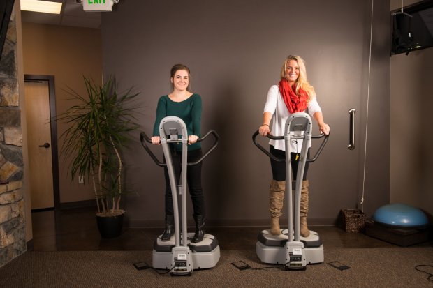 Two women standing on whole body vibration machines