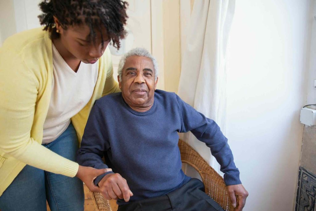 Woman caregiver helping an older man