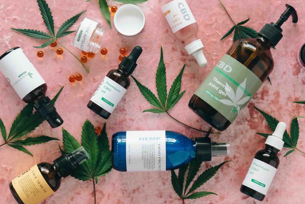 Various CBD Oils and Hemp Plant Leaves on a table
