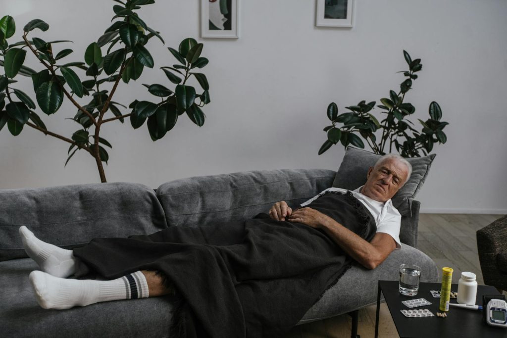 Man resting on the couch, looking in pain