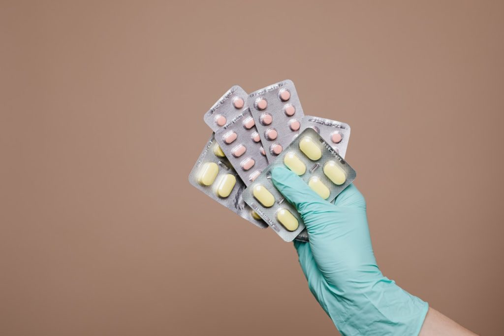 Gloved hand holding medications